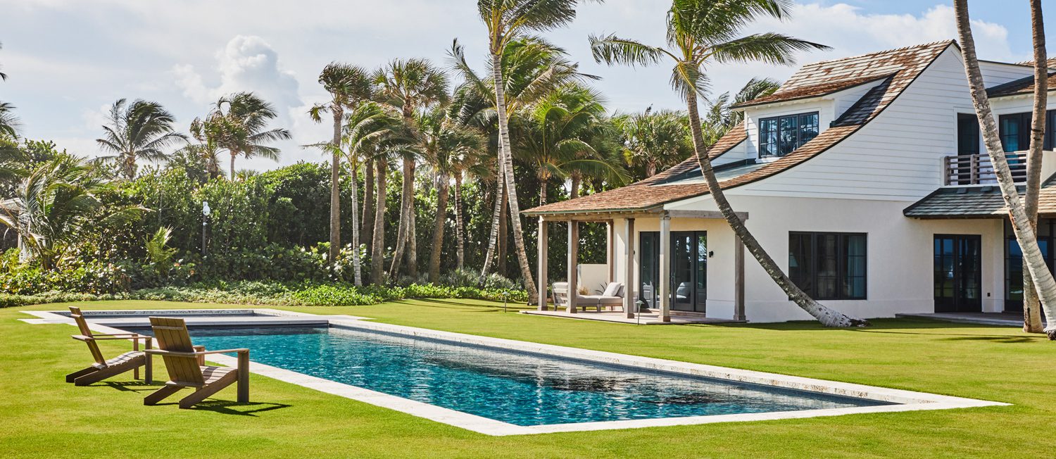 佛罗里达家庭外部环绕着Thomas Melhorn游泳池和棕榈树