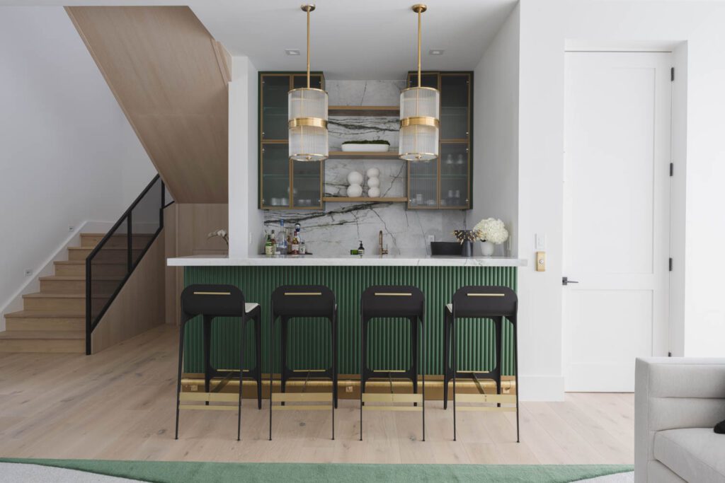 Gabriel Scott凳子拉上自定义吧台,它装上Arca石大理石大理石并用Circa Lighting插件点亮