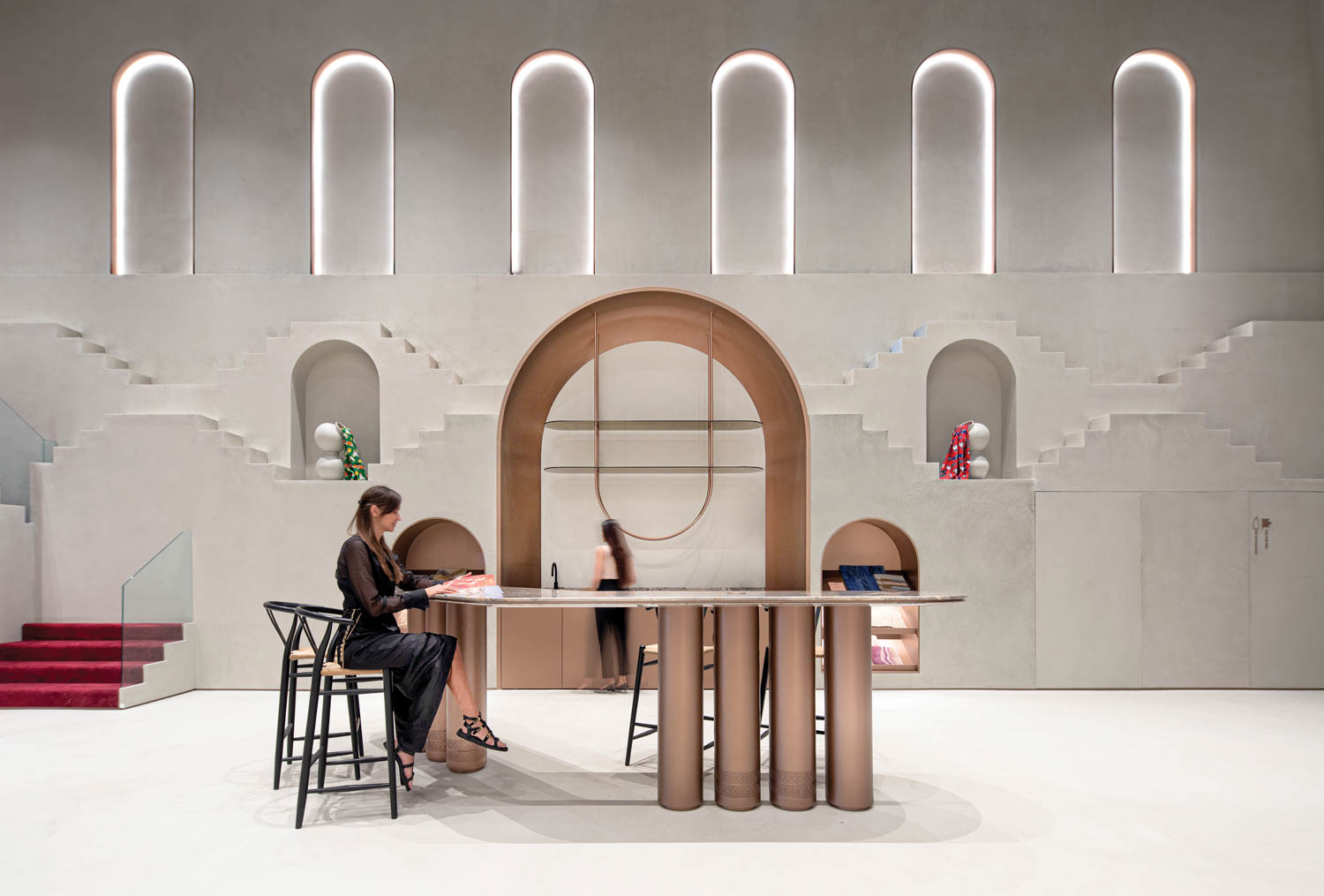 一个女人坐在JaipurRugs一排停机门前的表