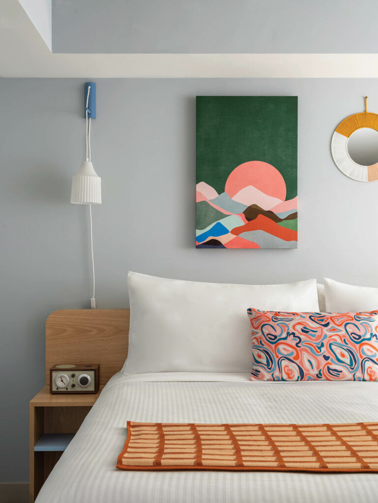 回游套房卧室带明亮艺术作品和模式化枕头