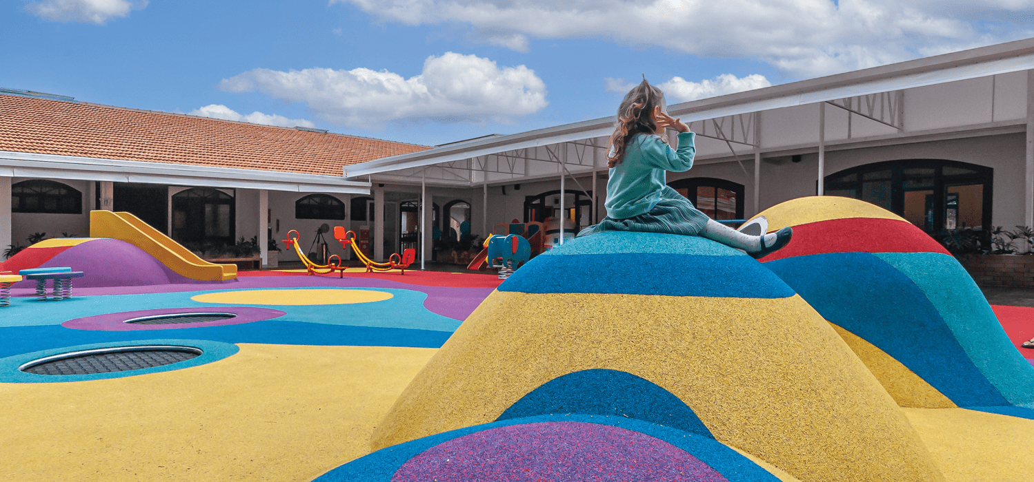 儿童坐在学校游乐场多色丘上