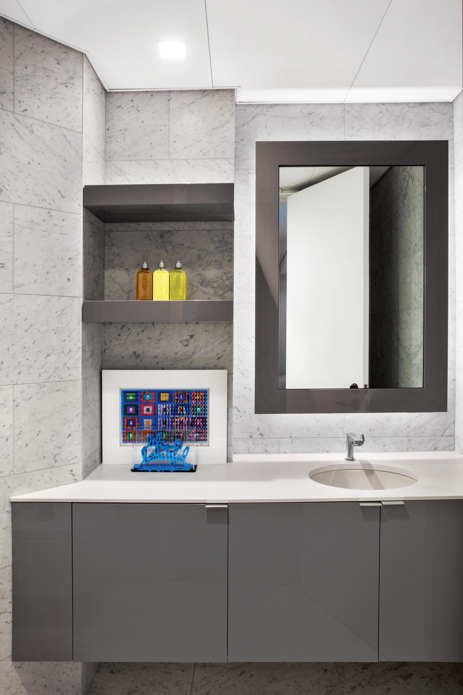 洗手间由卡拉拉大理石瓦和定制装饰柜组成