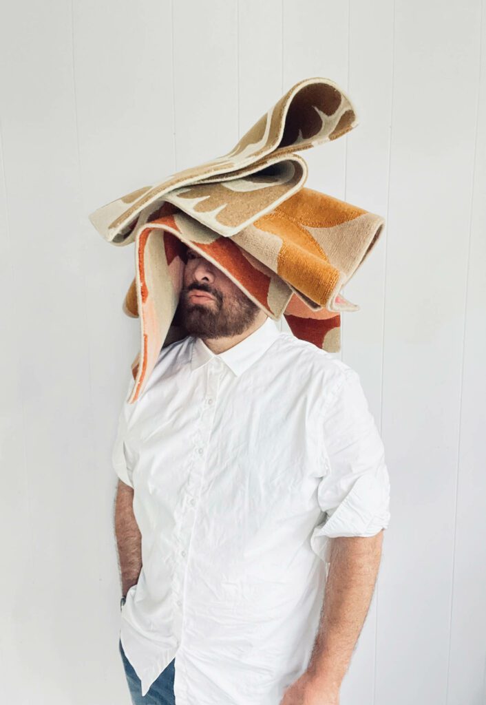 Peter Valcarcel平衡他新收集的地毯头部