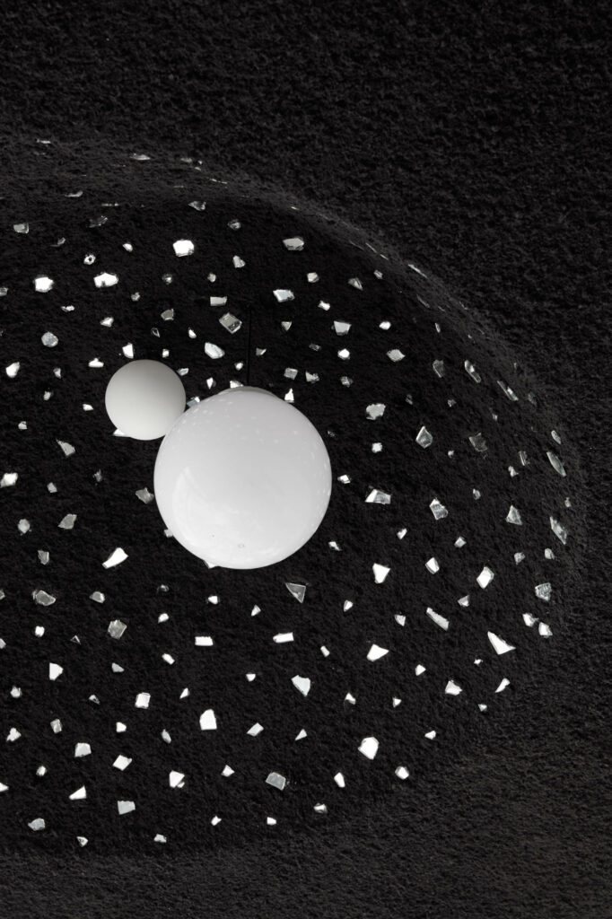 纹理天花板上数列圆点与反射碎片拼接,下挂定制光球