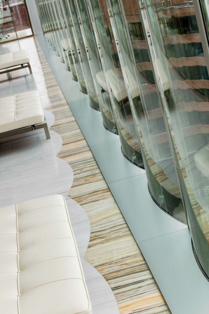 PoulKjærholmPK80长椅沿走廊行,由Lasa和Bella Rosa石块组成