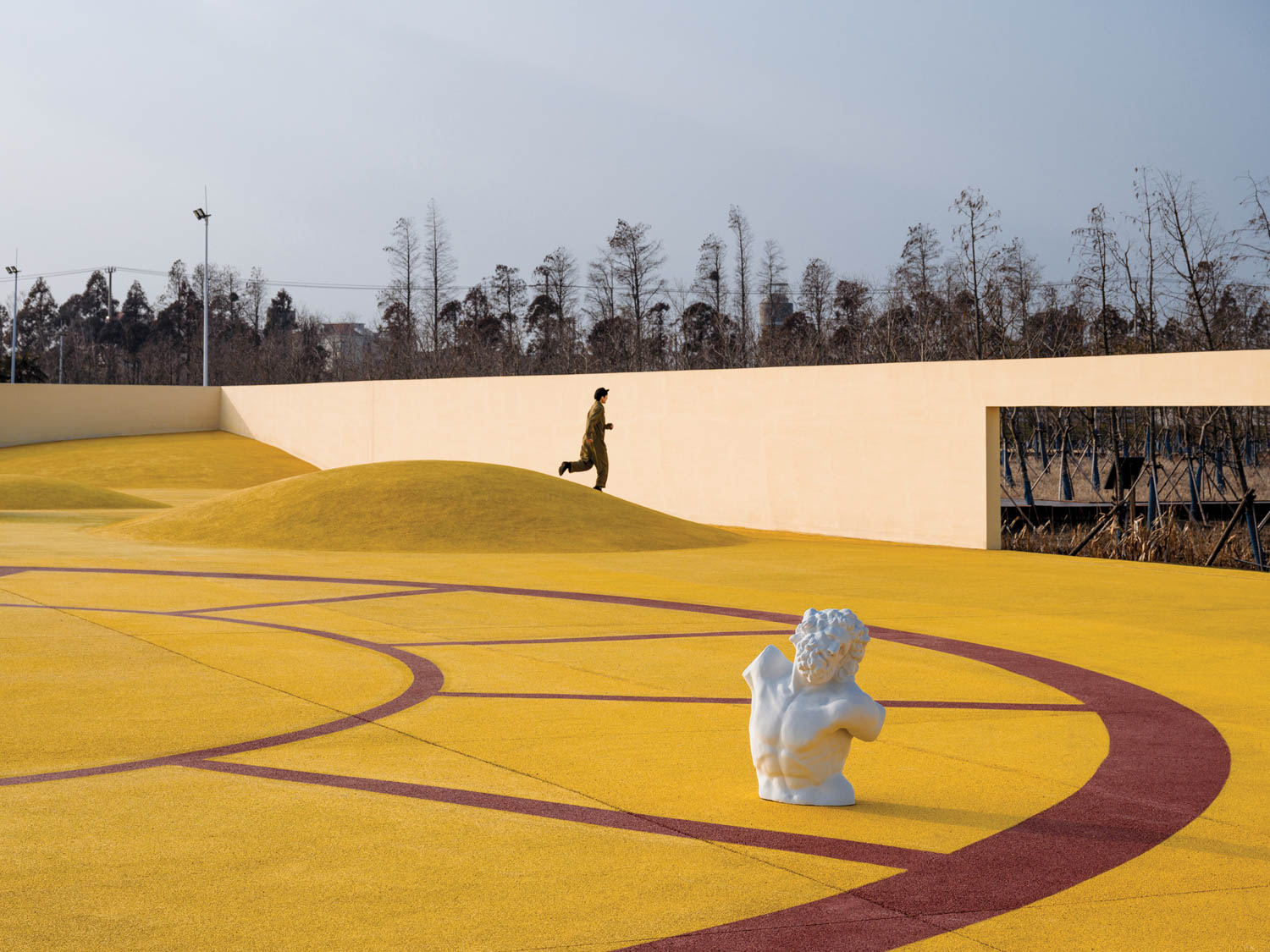 黄水泥馆旁坐着 后排有个人跑步