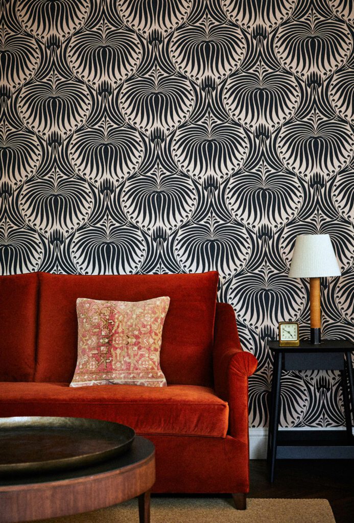 卧室内带红色沙发和欧拉塔壁纸的静坐区