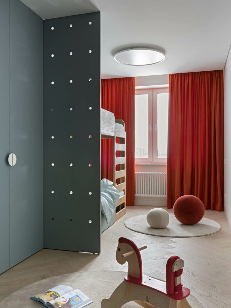 儿童室中装有定制床、斜线天花板光和关联织物地毯