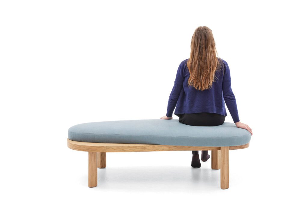 一个女人背靠背转离镜头 长椅上带蓝衬垫