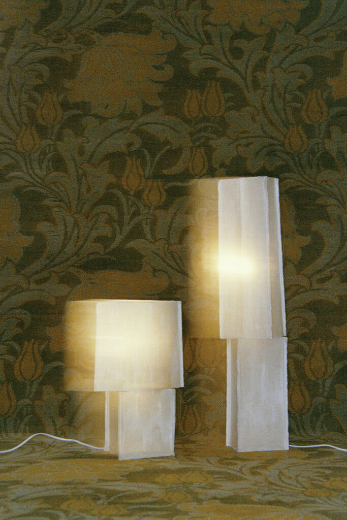 双长方形灯固定装置对着绿墙纸坐在地板上