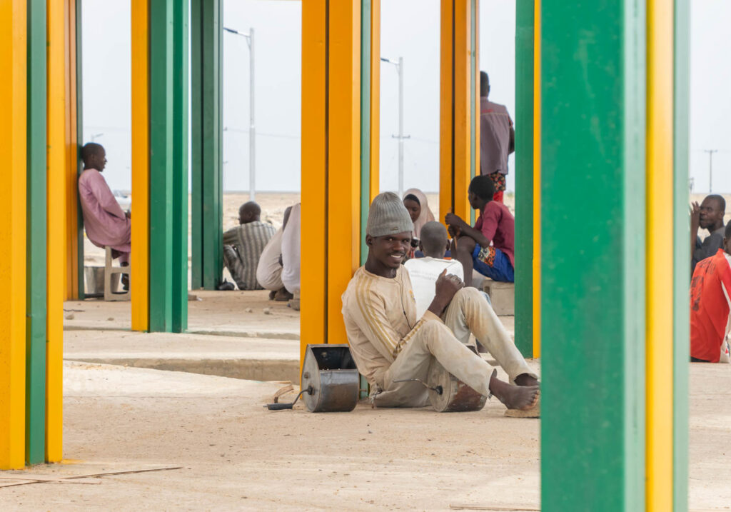 人坐在北尼日利亚村黄绿梁上笑