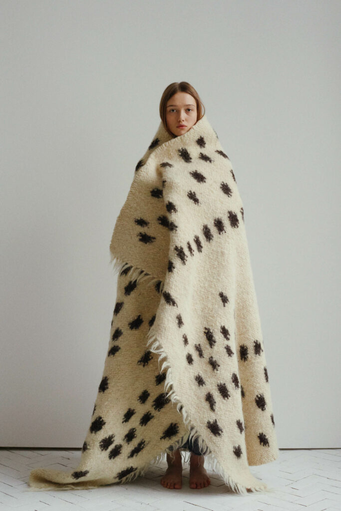 一个女人站在白地毯上带棕色斑点