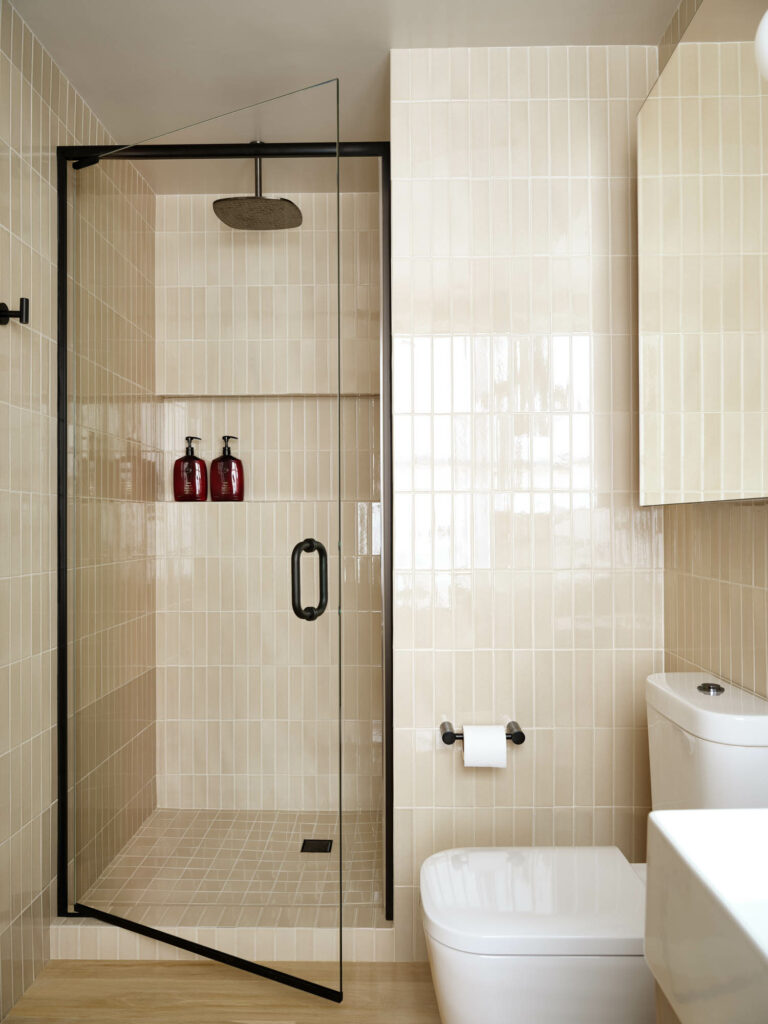 现代卫生间配有米格垂直瓦和玻璃门淋浴