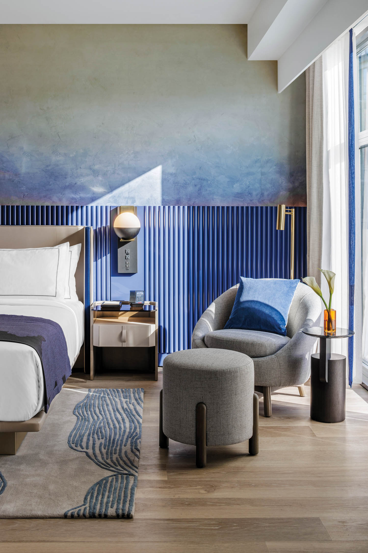 蓝色垂直面板背后的床在一个酒店的客房