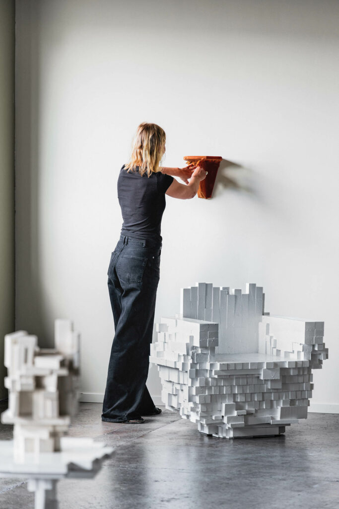 设计师在工作室墙上搭建湿装皮架