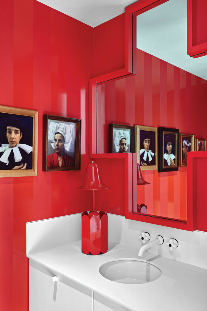 卫生间配有红墙、镜像和美术
