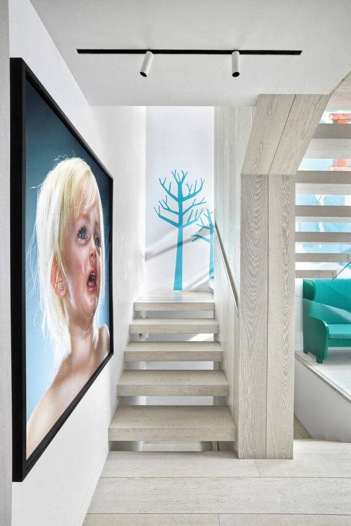 楼梯间配有小美术馆和蓝衣架