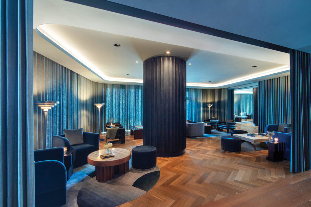 Vesper内装鸡尾酒表、深蓝天鹅绒臂椅和深窗帘