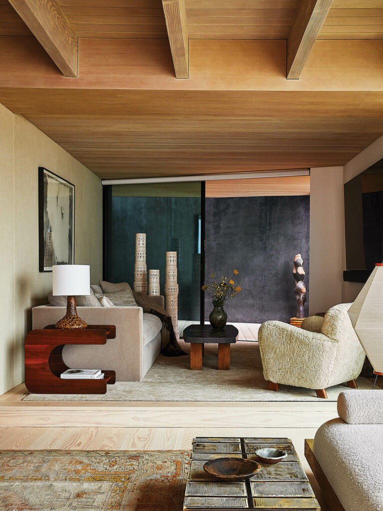 起居室带图腾灯、白臂椅和暴露木板