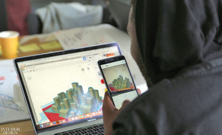 学生制作笔记本电脑并查看手机上同一张图像