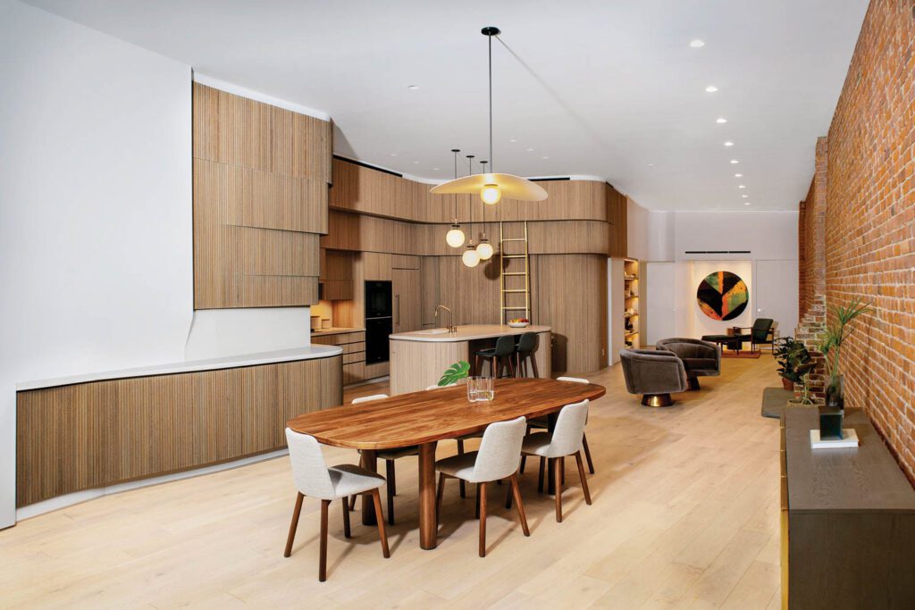 木金属组合通过核桃家具和金盘嵌入相邻餐厅