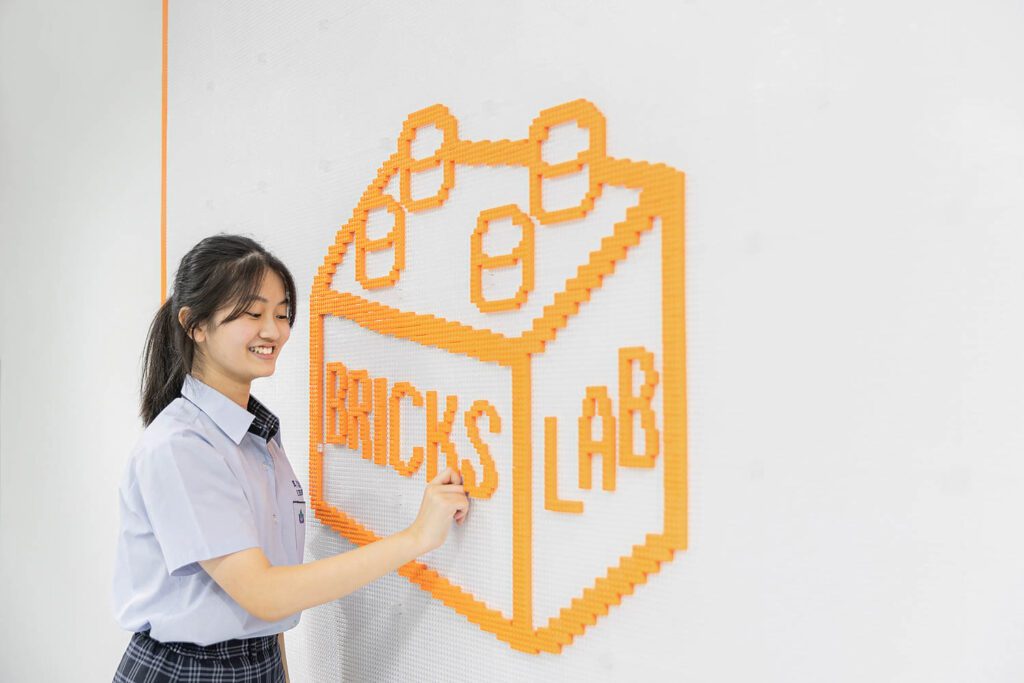 女孩指向墙上布列克斯实验室标识