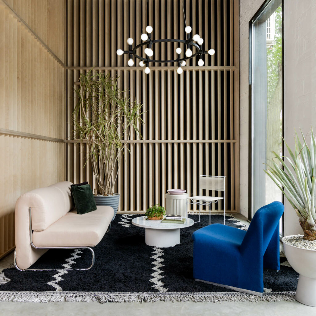 多环形嵌套灯挂在蓝客椅和白沙发上方