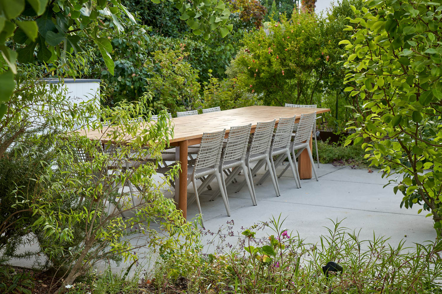 花园里木餐桌环绕着灰色椅子