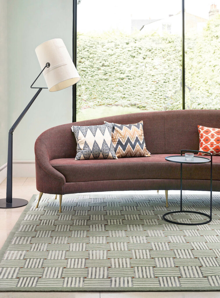 沙发坐在绿色地毯上并带几何图案