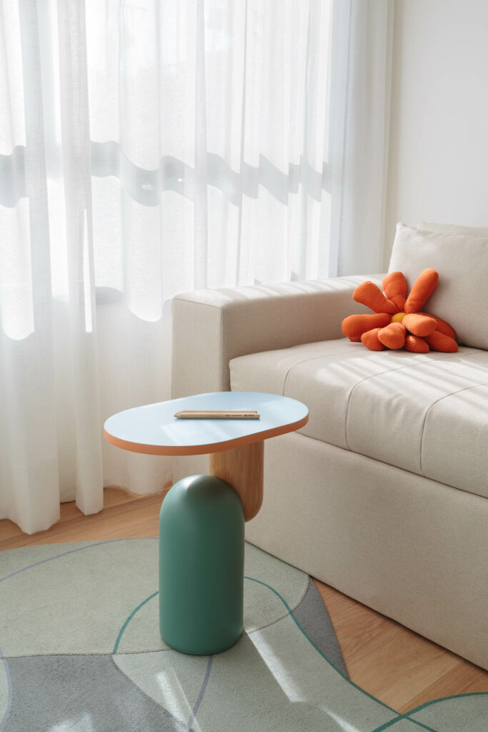 几何表区靠近带亮橙色枕头的奶油沙发