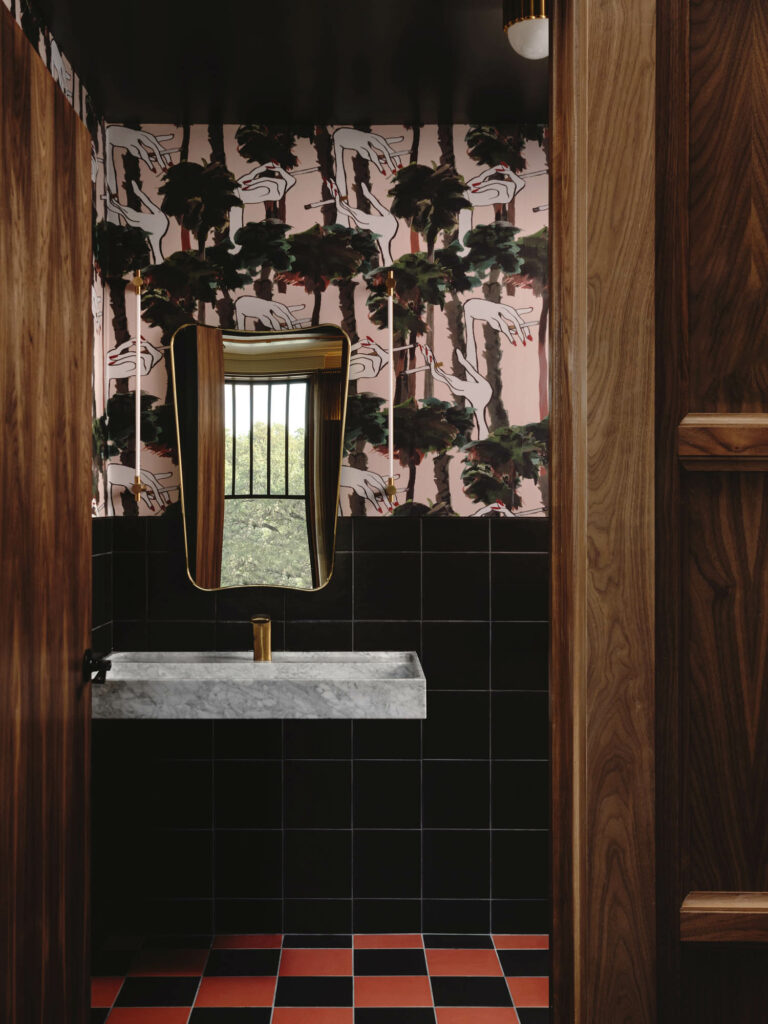 办公室卫生间配有粉色图形墙纸和红黑格板瓦