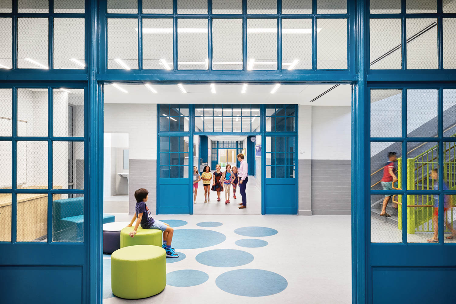 小孩坐在开房绿托普曼,地板上带蓝点